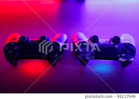 Gamepad on a wooden table with backlight. 98217646