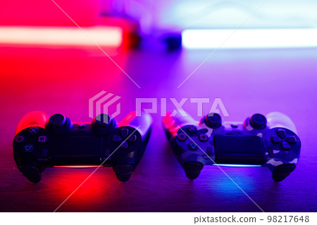Gamepad on a wooden table with backlight. 98217648