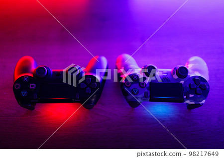 Gamepad on a wooden table with backlight. 98217649