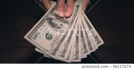 Hand holding money 100 dollars, investment and finance business concepts. Hand holding money 100 dollars, investment and finance business concepts. 98217679