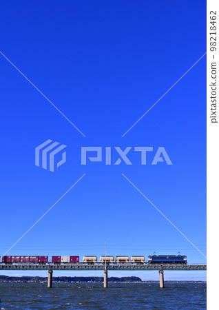 行駛在湛藍天空下的貨運列車 98218462