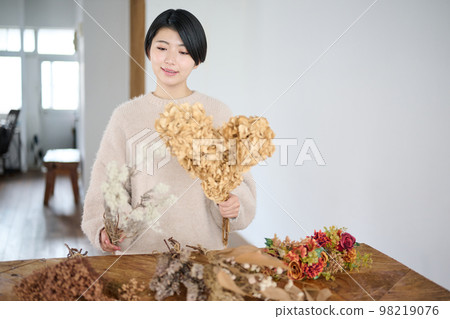 Young woman enjoying dried flowers 98219076