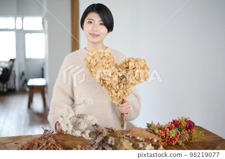 Young woman enjoying dried flowers 98219077
