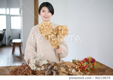 Young woman enjoying dried flowers Young woman enjoying dried flowers 98219079