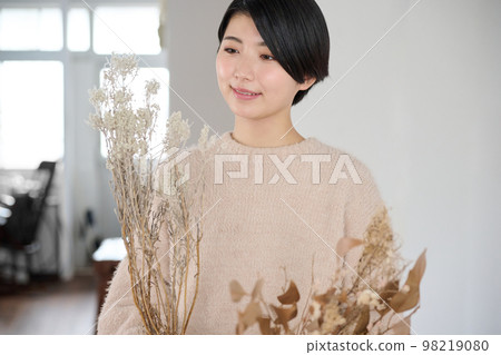Young woman enjoying dried flowers Young woman enjoying dried flowers 98219080