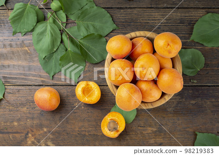 Delicious ripe apricots in a clay bowl on the table close-up. Delicious ripe apricots in a clay bowl on the table close-up. 98219383