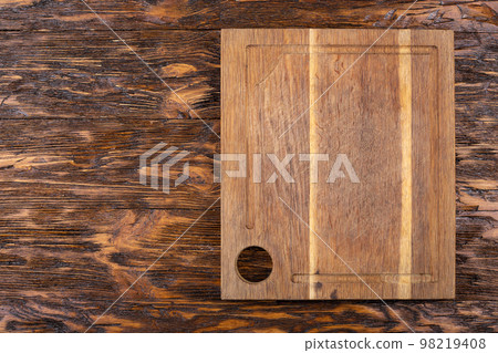 Empty old cutting board on a wooden background. Layout for the recipe. Empty old cutting board on a wooden background. Layout for the recipe. 98219408