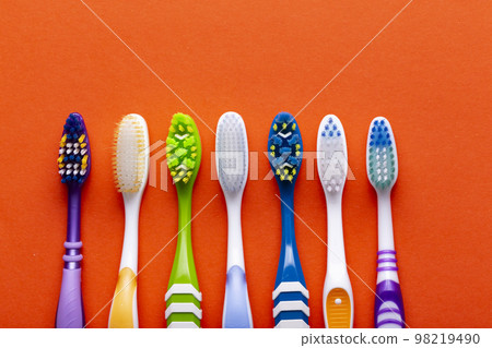Toothbrushes on a orange background. Concept toothbrush selection. Oral cavity care. Dental hygiene. 98219490