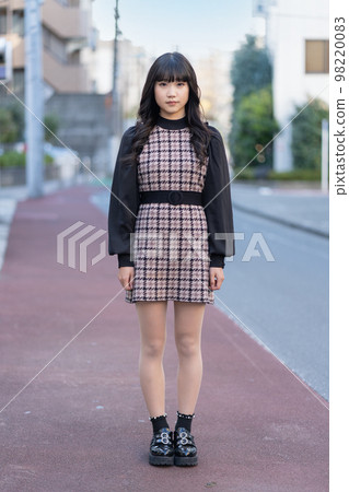 Generation Z girl standing straight on the road and looking at the camera Generation Z girl standing straight on the road and looking at the camera 98220083
