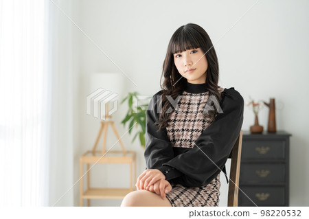 Z世代女孩坐在客廳的椅子上看著鏡頭 98220532