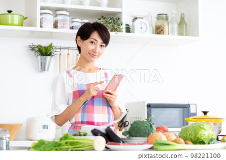 Middle-aged housewife in the kitchen Middle-aged housewife in the kitchen 98221100
