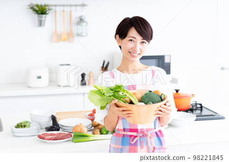 Middle-aged housewife in the kitchen Middle-aged housewife in the kitchen 98221845