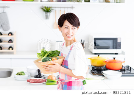Middle-aged housewife in the kitchen Middle-aged housewife in the kitchen 98221851