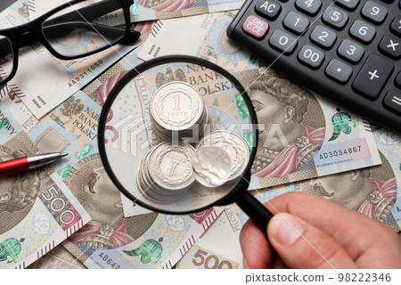 Man using mangifier, polish money concept 98222346
