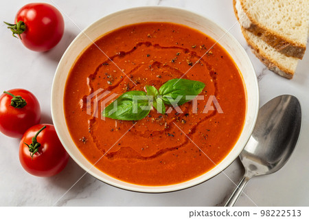 Hot tomato soup in a white bowl closeup. Hot tomato soup in a white bowl closeup. 98222513