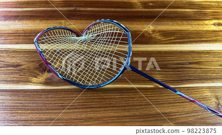 Close up broken badminton racket on brown wooden background Close up broken badminton racket on brown wooden background 98223875