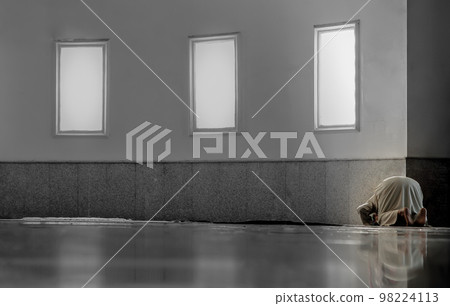 Religious muslim man sit on knee and head touch floor on the ground inside the mosque. 98224113