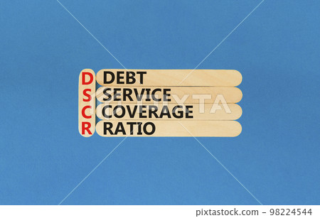 DSCR debt service coverage ratio symbol. Concept words DSCR debt service coverage ratio on wooden stick on beautiful blue background. Business DSCR debt service coverage ratio concept. Copy space. 98224544