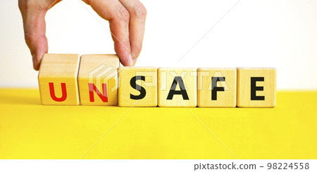 Safe or unsafe symbol. Concept word Safe Unsafe on wooden cubes. Businessman hand. Beautiful yellow table white background. Business safe or unsafe concept. Copy space. Safe or unsafe symbol. Concept word Safe Unsafe on wooden cubes. Businessman hand. Beautiful yellow table white background. Business safe or unsafe concept. Copy space. 98224558