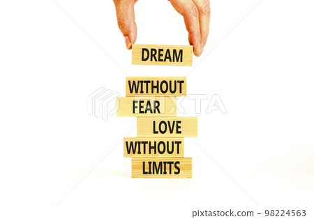 Dream and love symbol. Concept words Dream without fear love without limits on wooden blocks on a beautiful white table white background. Businessman hand. Dream and love without limits concept. Dream and love symbol. Concept words Dream without fear love without limits on wooden blocks on a beautiful white table white background. Businessman hand. Dream and love without limits concept. 98224563