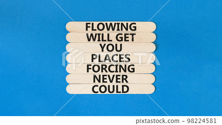 Flowing symbol. Concept words Flowing will get you places forcing never could on wooden sticks. Beautiful blue table blue background copy space. Business motivational flowing concept. 98224581