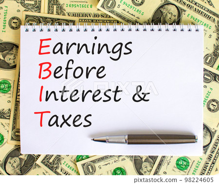 EBIT symbol. Concept words EBIT earnings before interest and taxes on white note on beautiful white background. Dollar bills. Business EBIT earnings before interest and taxes concept. Copy space. 98224605