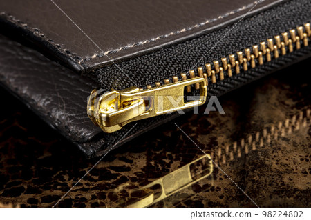 Part of a leather wallet with a zipper. Part of a leather wallet with a zipper. 98224802