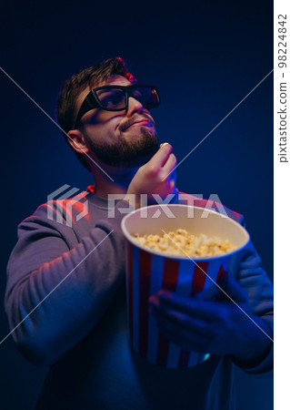 A guy in 3 glasses is watching a movie. Waiting for the premiere. A guy in 3 glasses is watching a movie. Waiting for the premiere. 98224842