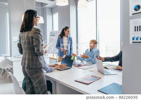 Coworkers discussing business ideas while working in office Coworkers discussing business ideas while working in office 98226030