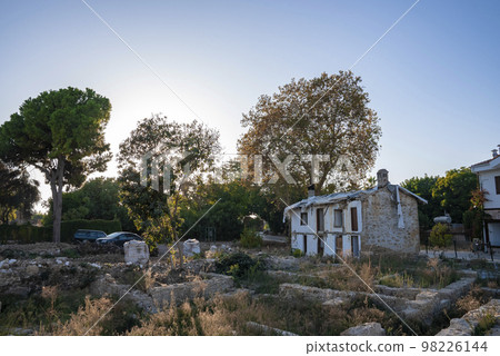 View of plants growing on land in front of old abandoned house with trees and clear blue sky in the background at Turkey 98226144