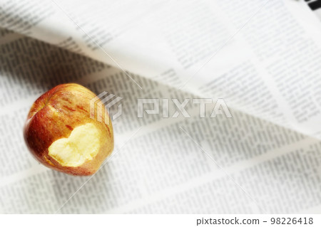 Eaten apple and newspaper Eaten apple and newspaper 98226418