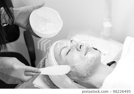 The process of applying a moisturizing mask to the face in a spa salon. The process of applying a moisturizing mask to the face in a spa salon. 98226495