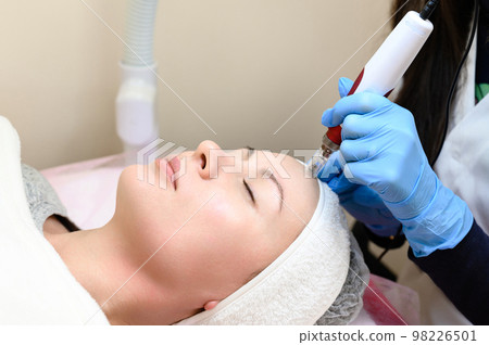 A beautician performs a rejuvenating mesotherapy procedure using dermapen. 98226501