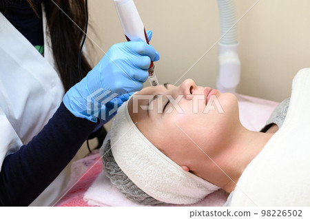 A beautician performs a rejuvenating mesotherapy procedure using dermapen. A beautician performs a rejuvenating mesotherapy procedure using dermapen. 98226502