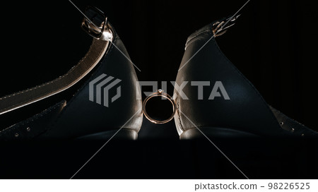 Wedding ring between two shoes close-up. Wedding ring between two shoes close-up. 98226525