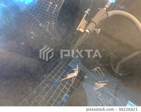 Shot blasting. Shot blasting of model printed on 3D printer from polyamide powder. A worker in sealed rubber gloves cleans the object by shot blasting in a shot blasting chamber. Industrial machine 98226821