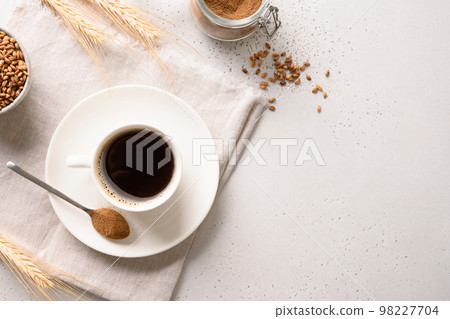 Barley coffee in white cup and ears of barley on white background. Barley coffee in white cup and ears of barley on white background. 98227704