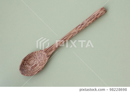 Top view Wooden spoon with texture on light green background. 98228698
