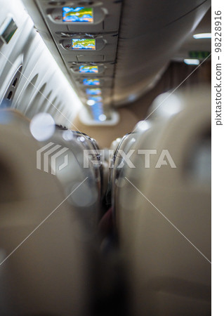 A vertical photo of the plane's interior between the rows of seats. A vertical photo of the plane's interior between the rows of seats. 98228916