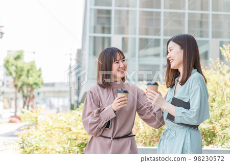 Female friends who drink coffee in front of the building, OL, business woman, female college student, university student 98230572