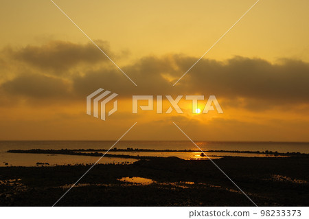 The morning sun hidden behind clouds and the light shining into the Ariake Sea The morning sun hidden behind clouds and the light shining into the Ariake Sea 98233373