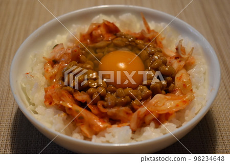 Natto kimchi TKG served on a white glass plate 98234648