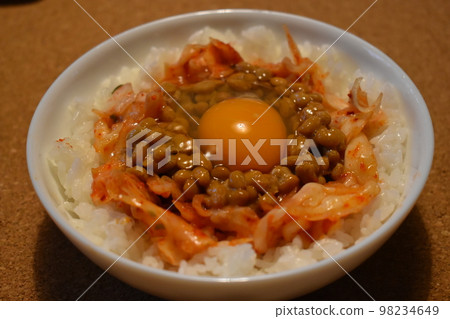 Natto kimchi TKG served on a white glass plate 98234649