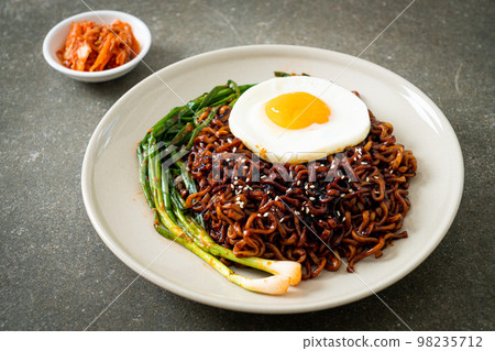 dried Korean spicy black sauce instant noodles with fried egg and kimchi 98235712
