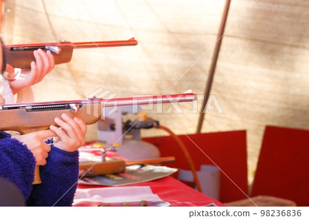 A boy playing a shooting game at the fair 98236836
