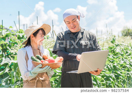 Asian men and women (men and women) managing agriculture on a laptop Asian men and women (men and women) managing agriculture on a laptop 98237584