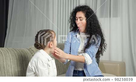 Speech therapist helps girl kid make correct sound at home Speech therapist helps girl kid make correct sound at home 98238039