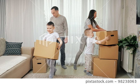 Family carries boxes and moves into purchased apartment 98238063
