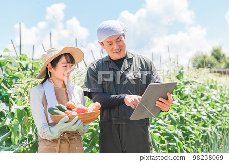 Asian men and women (men and women) who manage agriculture with a tablet PC Asian men and women (men and women) who manage agriculture with a tablet PC 98238069