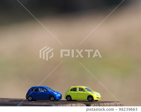 Landscape with minicars: yellow and blue march with autumn colors in the background Landscape with minicars: yellow and blue march with autumn colors in the background 98239663
